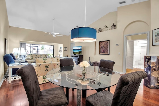 dining room with hardwood / wood-style flooring, ceiling fan, and high vaulted ceiling