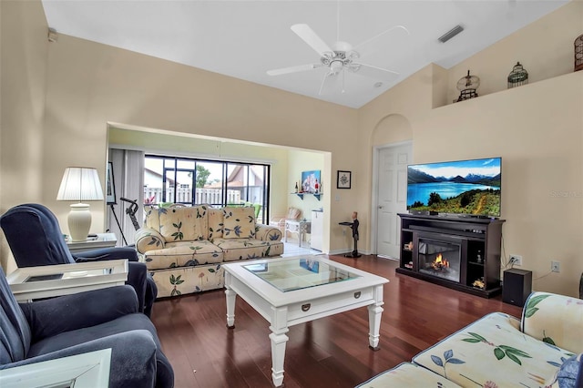 living room with ceiling fan, dark wood-type flooring, and lofted ceiling