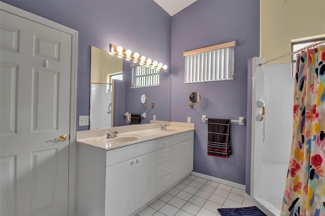 bathroom with tile patterned flooring, vanity, and walk in shower