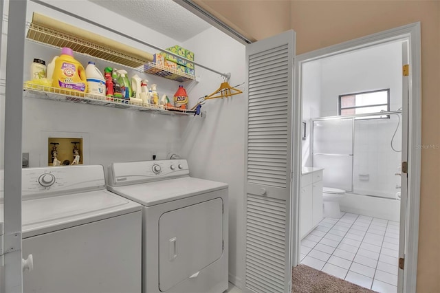 washroom featuring light tile patterned floors, a textured ceiling, and independent washer and dryer