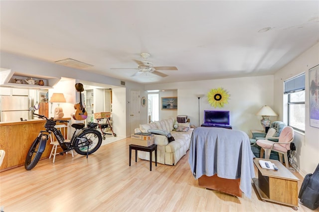 living room with ceiling fan and light hardwood / wood-style floors