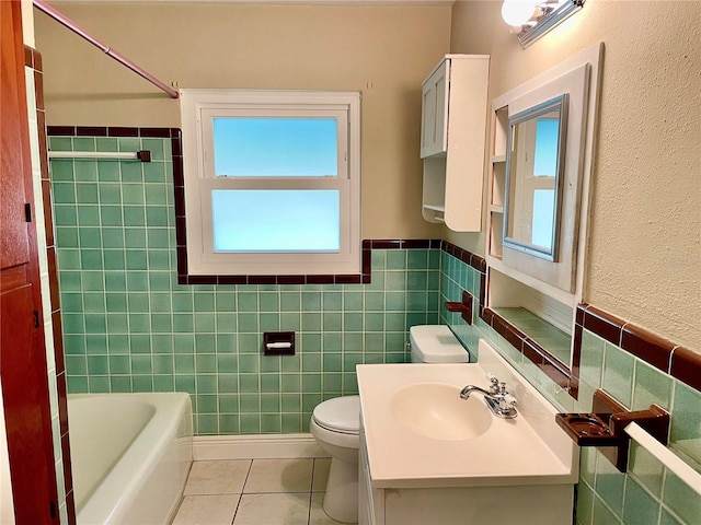 bathroom with tile patterned floors, plenty of natural light, and tile walls