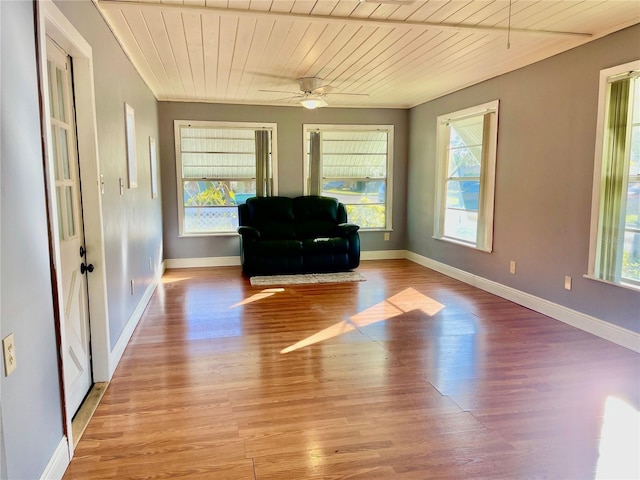 unfurnished room with ceiling fan, light wood-type flooring, a wealth of natural light, and wooden ceiling