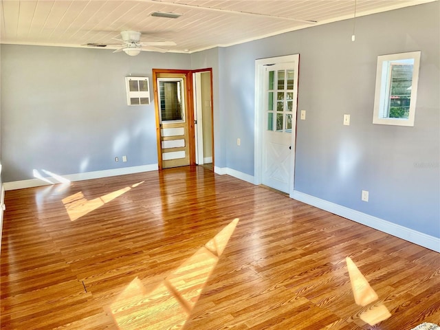 spare room featuring light hardwood / wood-style floors, an AC wall unit, ceiling fan, and wood ceiling