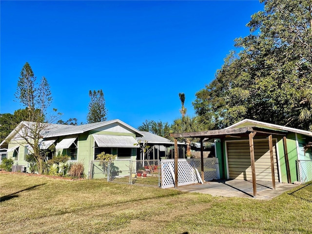 rear view of property with central AC and a yard