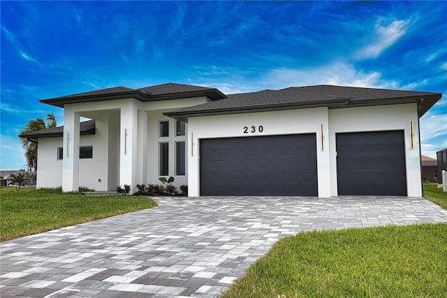 prairie-style home featuring a front lawn and a garage