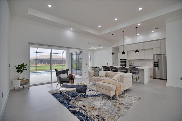 living room with a mountain view, light tile patterned floors, and a raised ceiling