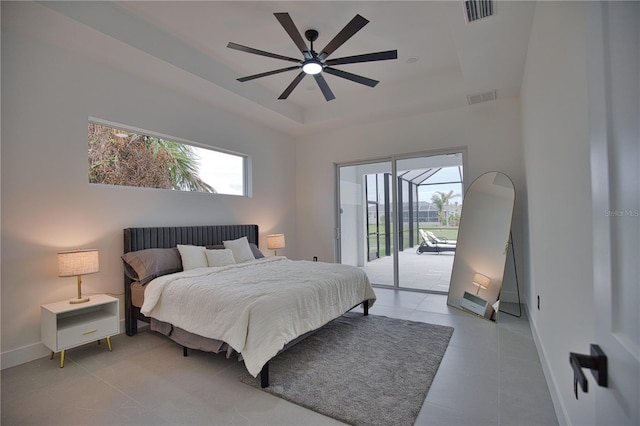 tiled bedroom with access to outside, ceiling fan, and a tray ceiling