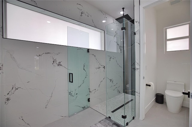 bathroom featuring tile patterned flooring, toilet, and a shower with door