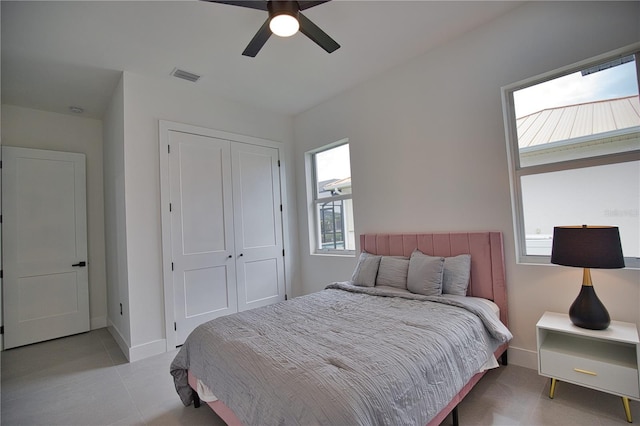 bedroom featuring ceiling fan, a closet, and multiple windows