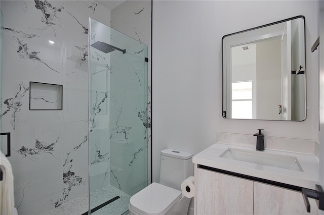 bathroom featuring vanity, a shower with shower door, and toilet