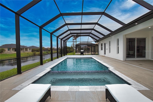 view of swimming pool featuring glass enclosure, an in ground hot tub, a water view, and a patio