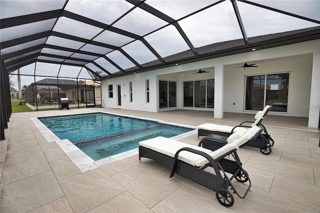 view of pool featuring glass enclosure, grilling area, and a patio area