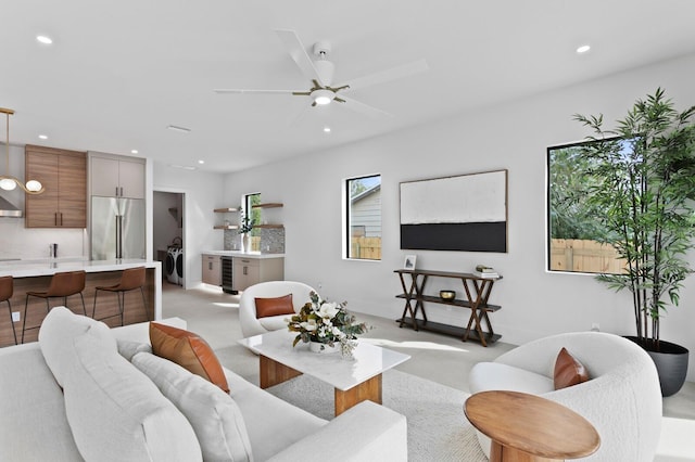 living room with ceiling fan, beverage cooler, and washing machine and clothes dryer