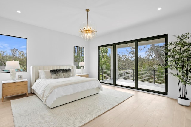 bedroom featuring multiple windows, a notable chandelier, access to exterior, and light hardwood / wood-style flooring