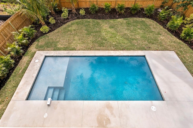 view of swimming pool featuring a yard