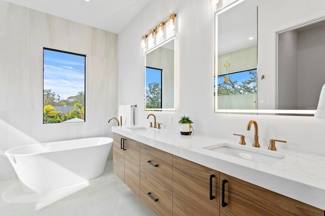 bathroom with vanity, a washtub, plenty of natural light, and tile walls