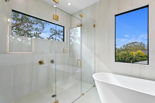 bathroom featuring separate shower and tub and tile walls