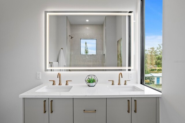 bathroom with tiled shower and vanity