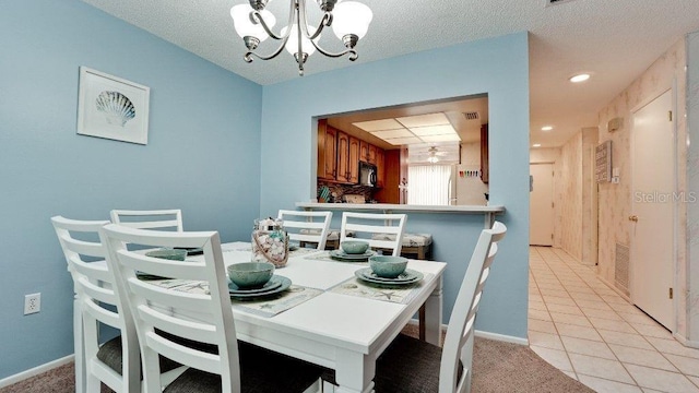 dining space with light tile patterned floors, a chandelier, and a textured ceiling