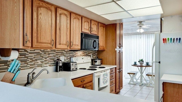 kitchen featuring white appliances, sink, ceiling fan, light tile patterned floors, and tasteful backsplash