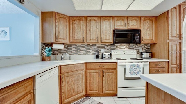 kitchen with backsplash, light tile patterned flooring, white appliances, and sink