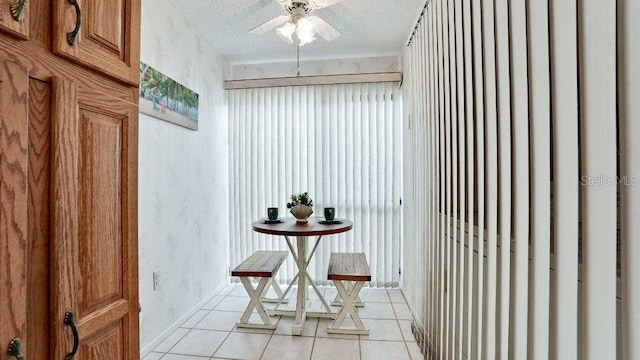 interior space featuring light tile patterned floors, a textured ceiling, and ceiling fan