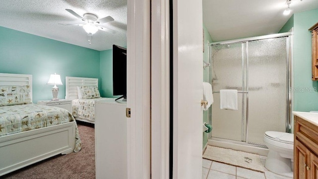 tiled bedroom with ceiling fan and a textured ceiling