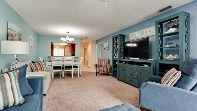 carpeted living room featuring a chandelier and a textured ceiling