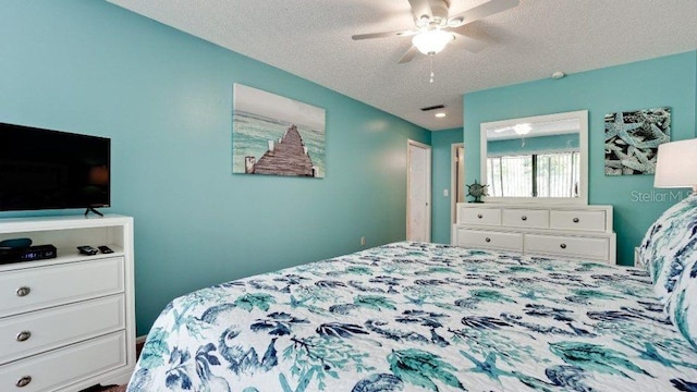 bedroom with ceiling fan and a textured ceiling