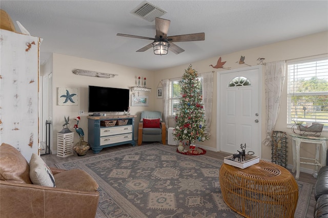 living room featuring ceiling fan and dark wood-type flooring