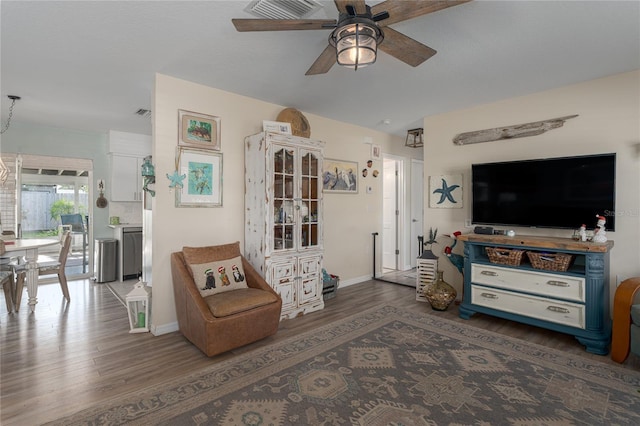 living room featuring ceiling fan and dark wood-type flooring