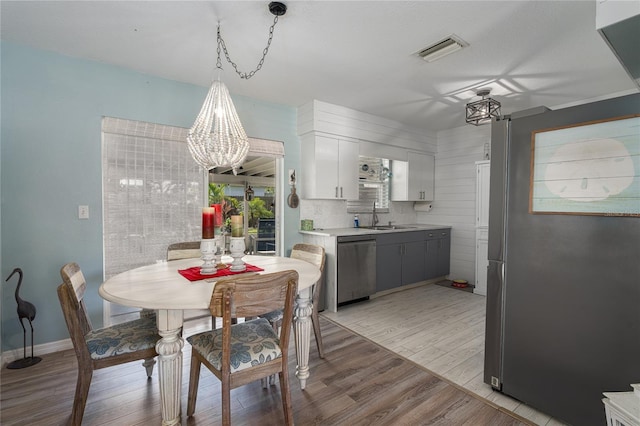 dining room with a chandelier, light hardwood / wood-style floors, and sink