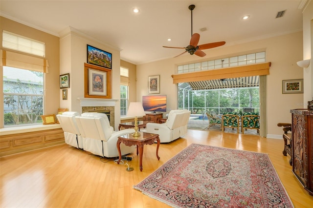 living room with wood-type flooring, ceiling fan, and crown molding