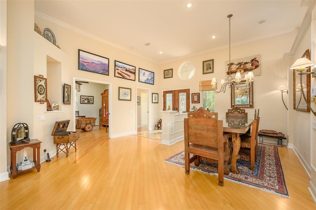 dining area featuring an inviting chandelier, ornamental molding, and light hardwood / wood-style flooring