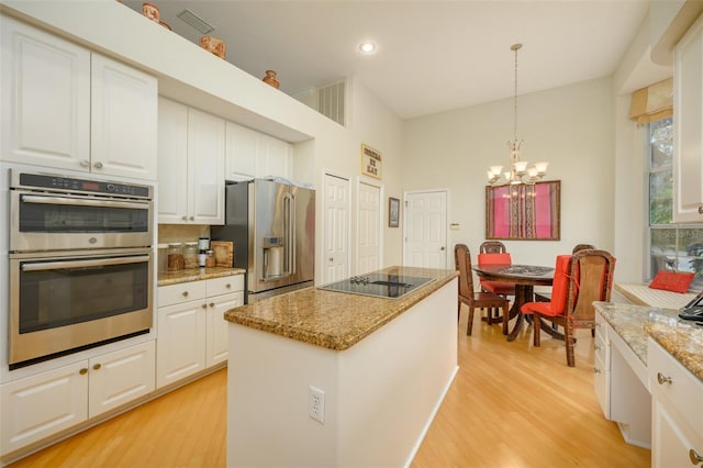 kitchen with white cabinetry, a kitchen island, hanging light fixtures, and appliances with stainless steel finishes