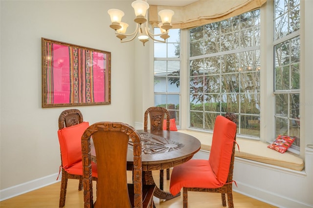 dining space with hardwood / wood-style floors and a notable chandelier