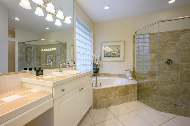 bathroom featuring tile patterned floors, vanity, and shower with separate bathtub