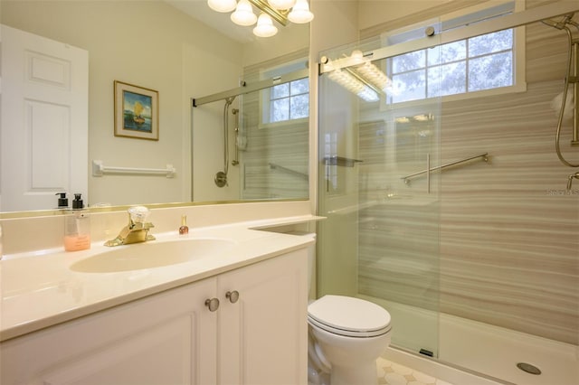 bathroom with vanity, toilet, and a shower with door