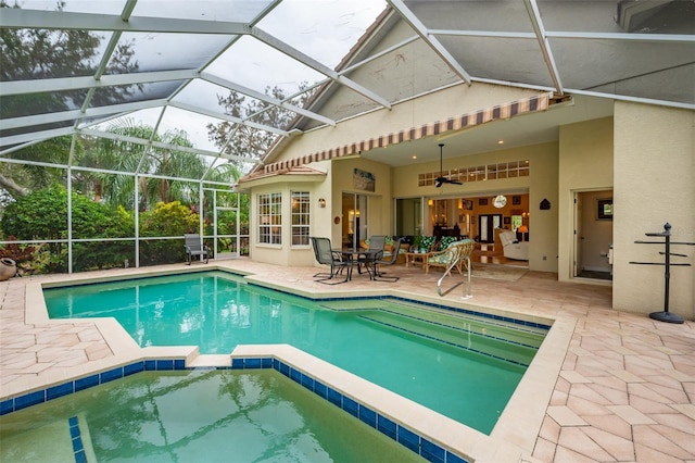 view of pool with ceiling fan, a patio area, and a lanai