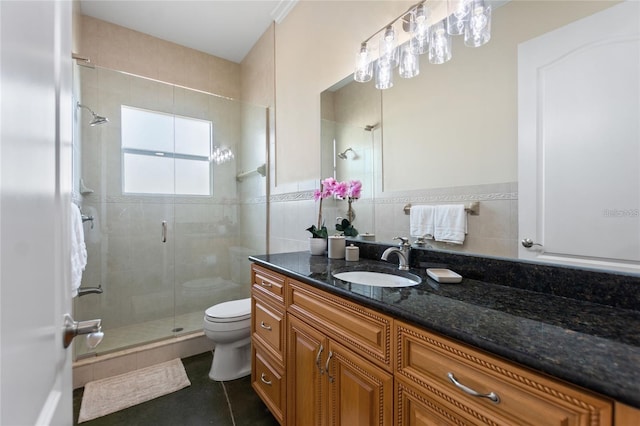 full bath with tile walls, toilet, a shower stall, vanity, and tile patterned floors