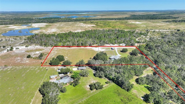 aerial view featuring a water view, a wooded view, and a rural view