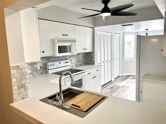 kitchen featuring white cabinetry, ceiling fan, backsplash, white appliances, and light wood-type flooring