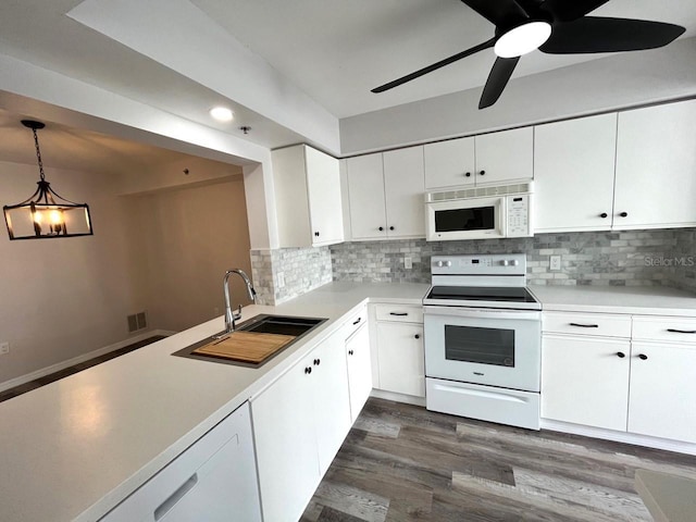 kitchen featuring white appliances, white cabinets, sink, decorative light fixtures, and dark hardwood / wood-style flooring