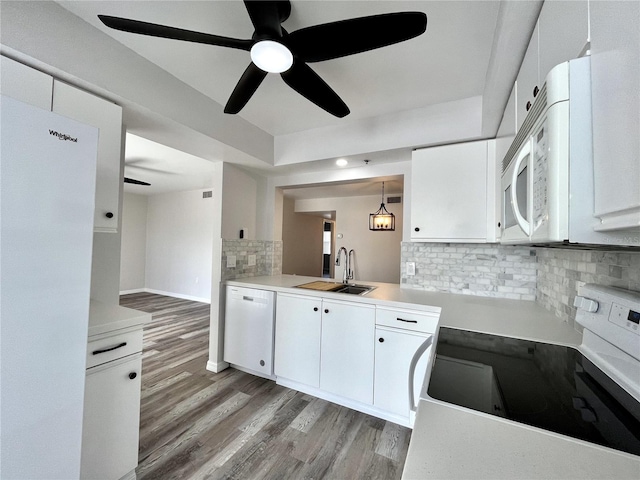 kitchen with backsplash, white appliances, sink, pendant lighting, and white cabinets