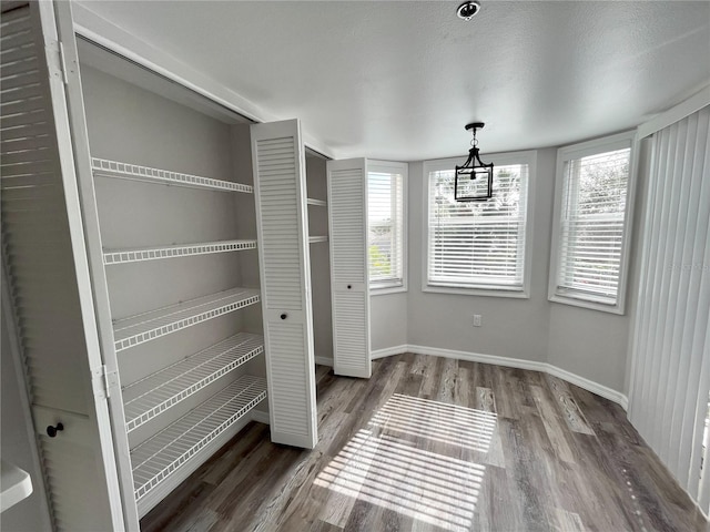 unfurnished dining area with hardwood / wood-style floors and a textured ceiling