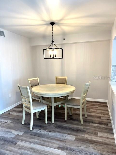 dining room featuring a notable chandelier and dark hardwood / wood-style flooring