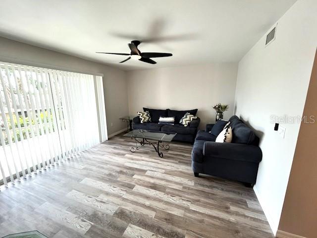 living room with light wood-type flooring and ceiling fan