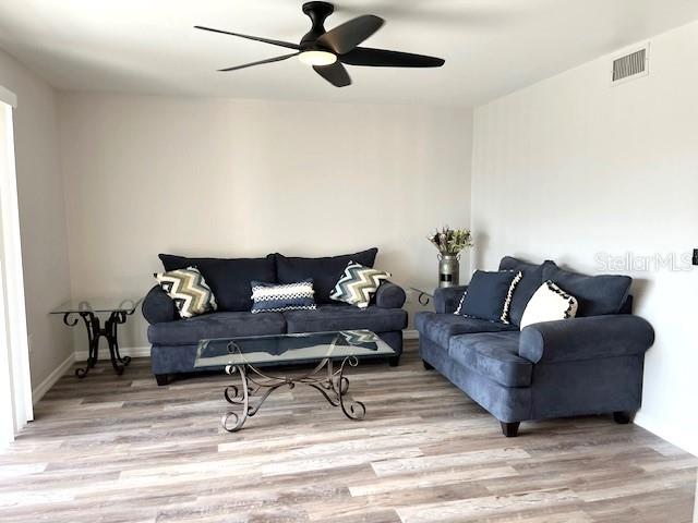 living room featuring ceiling fan and light wood-type flooring