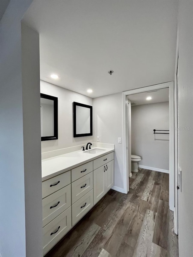 bathroom featuring toilet, vanity, and hardwood / wood-style flooring